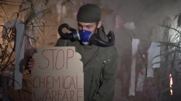 一个戴着防毒面具的男人举着一张海报 上面写着 停止化学战 环境保护的概念 空气污染 有害的排放 堆填区问题 — 图库视频影像