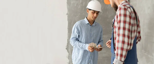 Junger Geschäftsmann Der Dem Bauunternehmer Geld Für Die Arbeit Gibt — Stockfoto