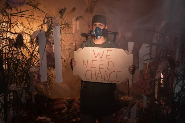 Man Gas Mask Holding Poster Words Need Change Burning Plastic — Stock Photo, Image