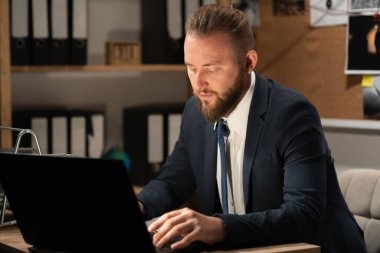 Dedektifler ofisindeki delilleri geceleri masasında çalışan bilgisayarla inceliyor. Boşluğu kopyala