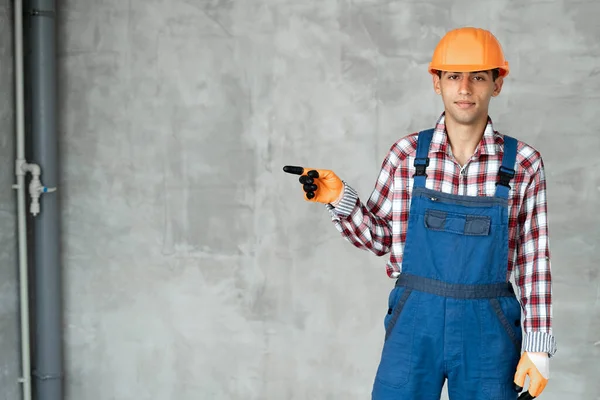 근육질 건축가 이상의 콘크리트 건설업자 유니폼을 헬멧을 엄지손가락을 옆으로 올려서 — 스톡 사진