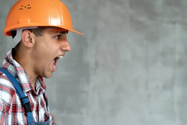 Joven Constructor Hombre Con Uniforme Construcción Casco Seguridad Sobre Gris —  Fotos de Stock