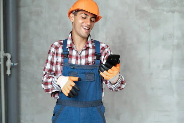 Feliz Sorrindo Trabalhador Masculino Construtor Capacete Amarelo Macacão Com Smartphone — Fotografia de Stock