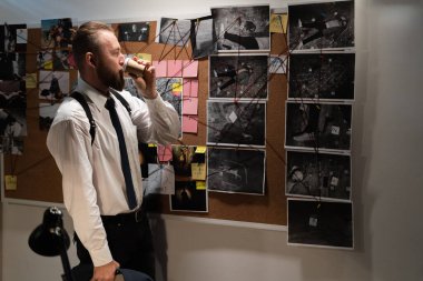 Dedektif ofisteki kanıt panosuna bakıyor, müfettiş gece işyerinde kahve içiyor, fotokopi çekiyor.