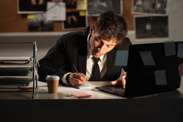 Detective working at desk in his office, processing evidence. copy space