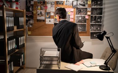 Dedektif ofisteki soruşturma kuruluna bakıyor. Çözüm arıyor. Geçmişe bakıyor. Boşluğu kopyala