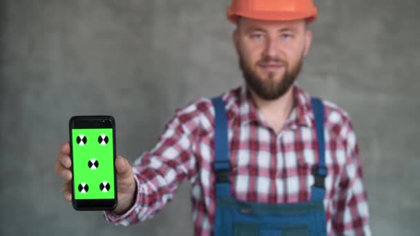 Usługi Budowlane Mężczyzna Budowlaniec Demonstrujący Pusty Smartfon Uśmiechnięty Mężczyzna Bezpiecznym — Wideo stockowe