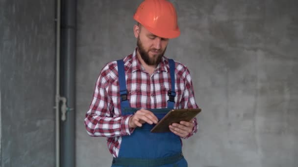 Construtor Reparador Trabalhando Segurando Tablet Digital Fundo Parede Cinza Capataz — Vídeo de Stock