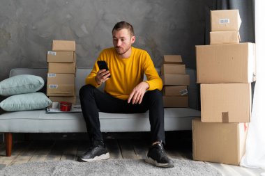 KOBİ serbest çalışanı ambalaj girişimi girişimcisi küçük işletme sahibi ile çalışıyor, kutuları paketlemek, müşterilere satmak, iş fikirlerini çevrimiçi satmak için çevrimiçi siparişleri kontrol ediyor. Boşluğu kopyala