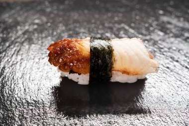 Siyah arka planda nefis unagi yılanbalığı nigiri sushi. Yılan balığı suşisi. Geleneksel Japon mutfağı kavramı
