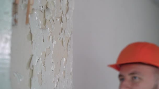 工人从墙上取出旧油漆 油漆剥落的房子的墙壁 油漆正在剥落 房屋装修内部更新 — 图库视频影像