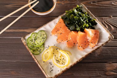 Sos, limon ve yosun ile servis edilmiş somon balığı. Japon Menüsü. Restoranda Japon yemeği. Üst görünüm