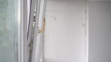 Tulumlu erkek işçi daireye pencere kuruyor. Profesyonel bir tamirci evdeki oturma odasının camını tamir ediyor..