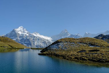 Grindelwald, İsviçre. Yüksek dağlar ve gölün yüzeyindeki yansıma. Göllü Dağ Vadisi. Yaz aylarında dağlık arazide manzara