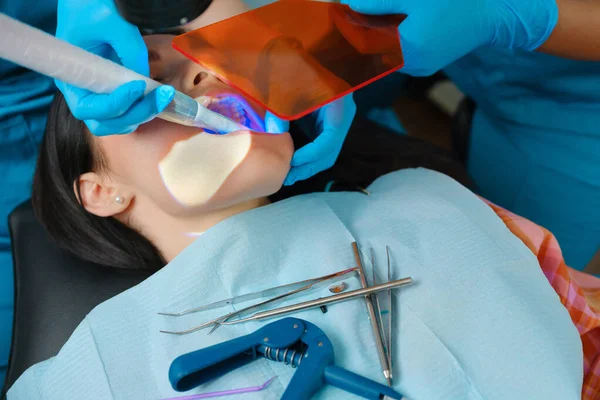 Dentista Utiliza Lámpara Fotopolímero Para Curar Los Dientes Cariosos Del —  Fotos de Stock