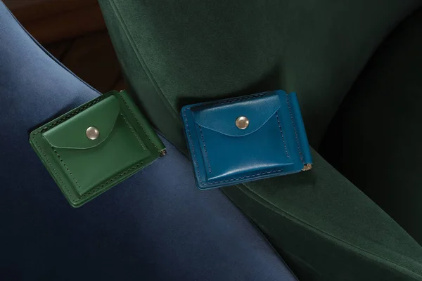 Two Colorful Fashionable Genuine Leather Wallets Lying Chair Green Blue lizenzfreie Stockbilder