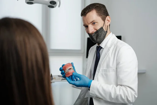 Male Dentist Holding Tooth Model Metal Braces Speaks His Patient — Foto de Stock