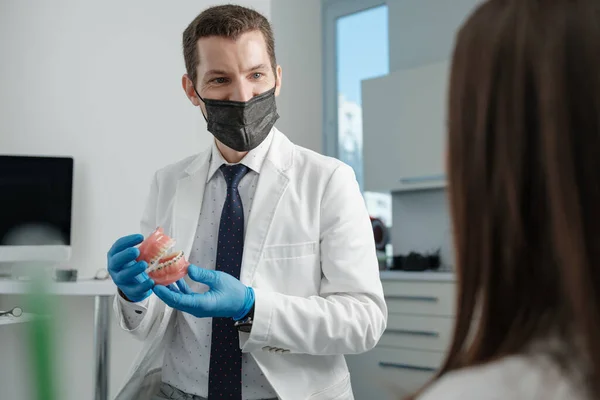 Male Dentist Holding Tooth Model Metal Braces Speaks His Patient — Foto de Stock