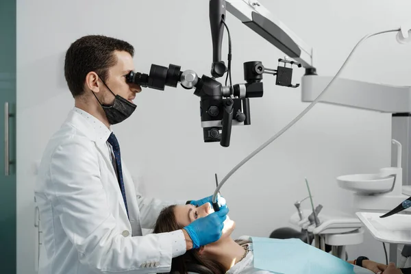Male Dentist Using Dental Microscope Treating Female Patient Teeth Dental — ストック写真