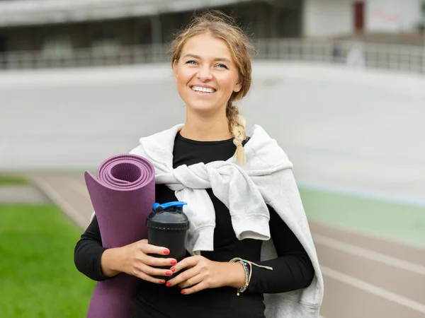 スポーツ競技場で運動した後 フィットネスラグと水のボトルでポーズ正の幸せな原因アジアの若い女性 — ストック写真