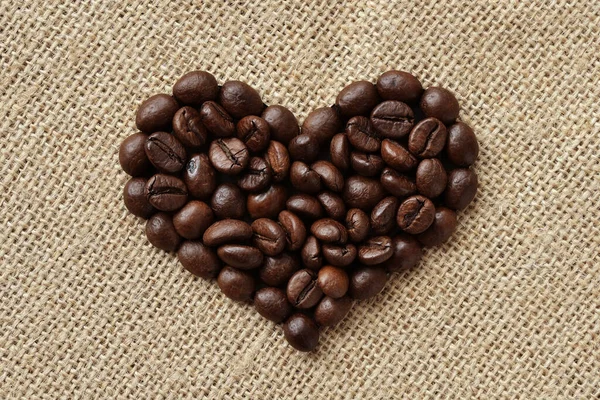 Kahve Çekirdekli Kalp Juta Arka Planda — Stok fotoğraf
