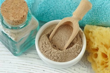 Tahta arka planda kaşıkla bir kasede Fas rhassoul çamuru