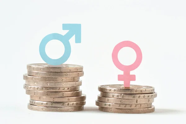 堆积如山的硬币上的男女符号 两性薪酬平等概念 — 图库照片
