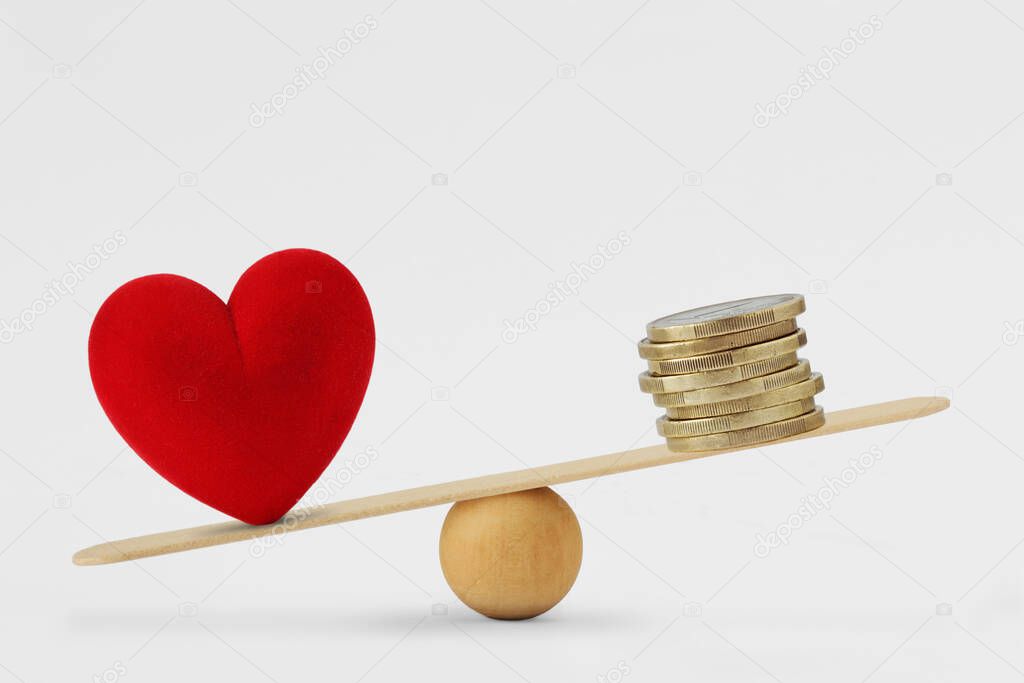Heart and money on balance scale - Concept of love priority in life