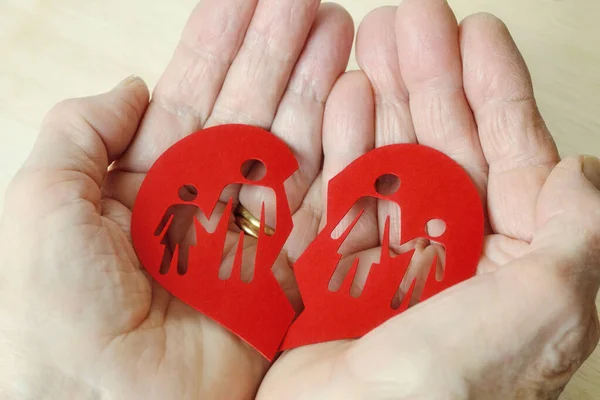 Woman hands holding paper broken heart with a family - Divorce and broken family concept