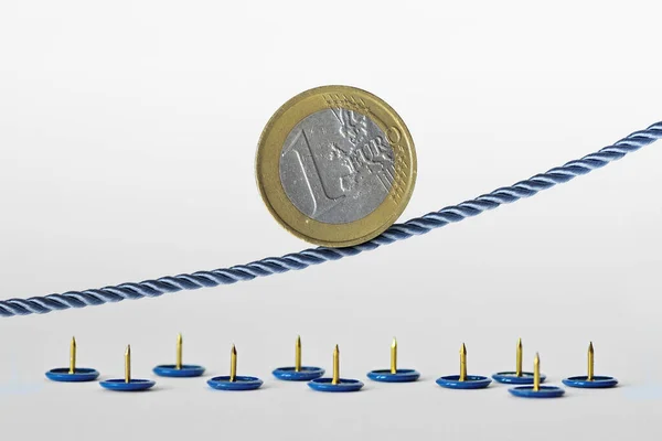 Euro coin on rope over push pins - Concept of upward trend of euro currency and euro currency risk