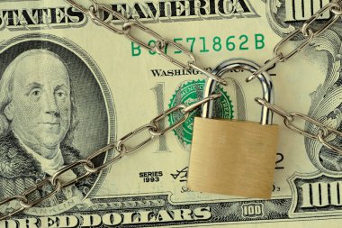 Zincir ve asma kilit ile kilitlenmiş dolar banknotunun kapanışı - sigorta, kefalet ve mali güvenlik kavramı