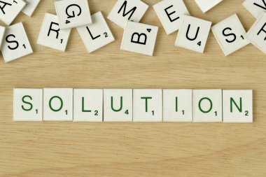 The word Solution written with scrabble game letters