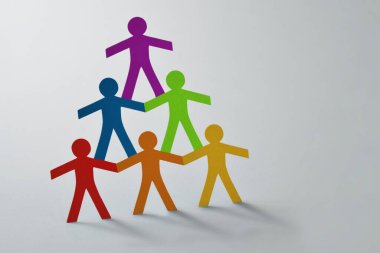 Beyaz arkaplanda renkli kağıt kesme piramidi - takım çalışması ve çeşitlilik kavramı