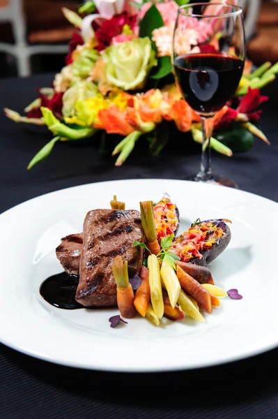 Roe szaftos steak egy tányér és pohár vörös bor — Stock Fotó