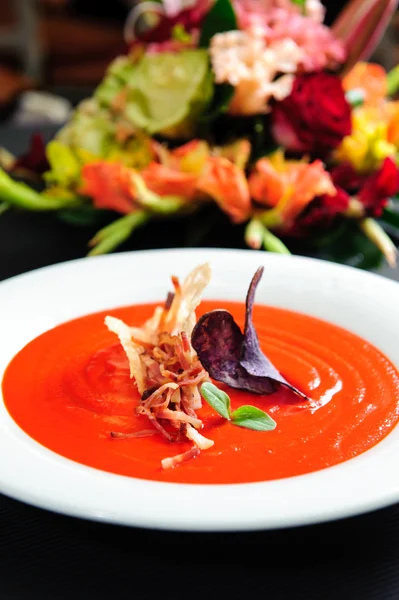 Tomato soup garnished with ham and herbs close-up — Stock Photo, Image