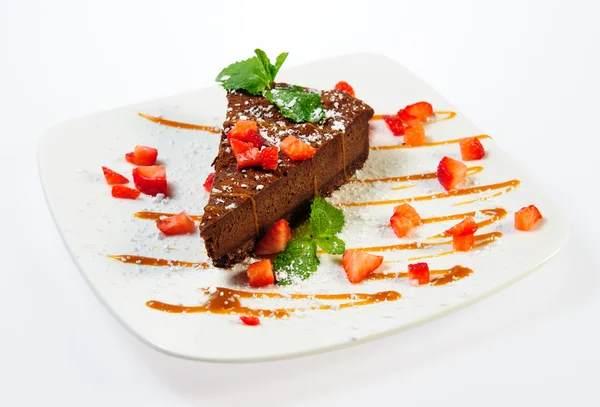Кусок сладкого шоколадного пирога с карамелью и свежей клубничкой — стоковое фото