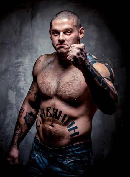 Jeune homme musclé agressif avec de nombreux tatouages — Photo