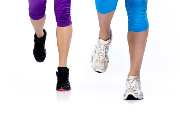 Close-up photo of two woman's legs running on a white background — Stock Photo, Image