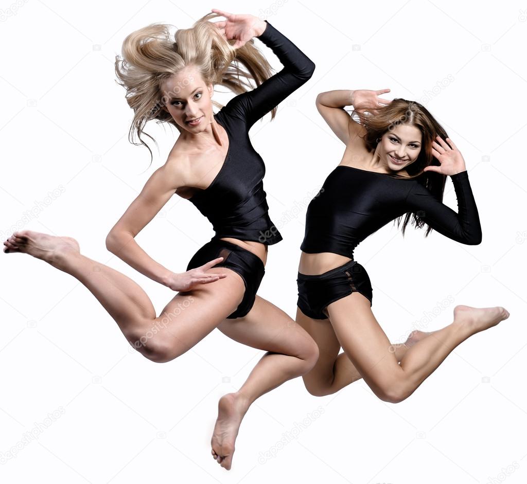 Two beautiful athletic girl jumping
