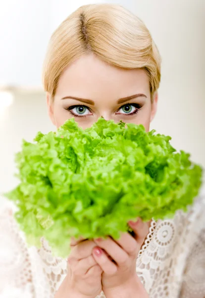 Porträt einer schönen blonden Frau, die sich hinter Salat versteckt — Stockfoto