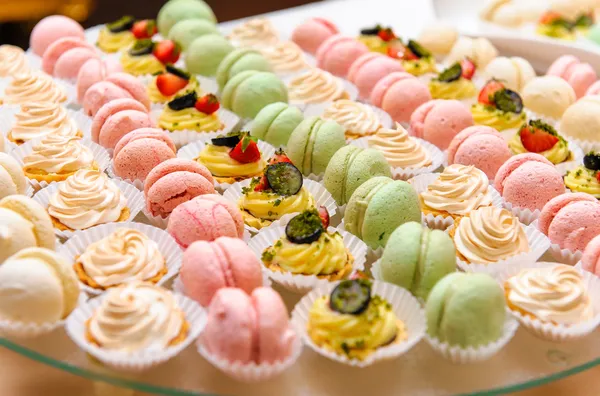 Bandeja con deliciosos pasteles y macarrones — Foto de Stock
