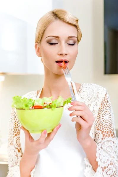 Portret van een mooie jonge vrouw eten plantaardige salade. — Stockfoto