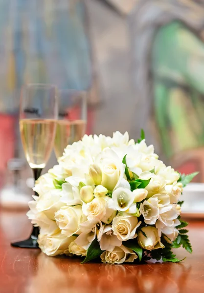 Belo buquê de noiva e dois copos de champanhe — Fotografia de Stock