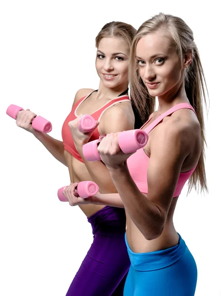 Two beautiful young woman doing fitness exercise with dumbbells — Stock Photo, Image