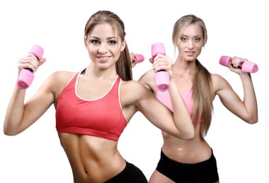 Two beautiful young women doing fitness exercise with dumbbells