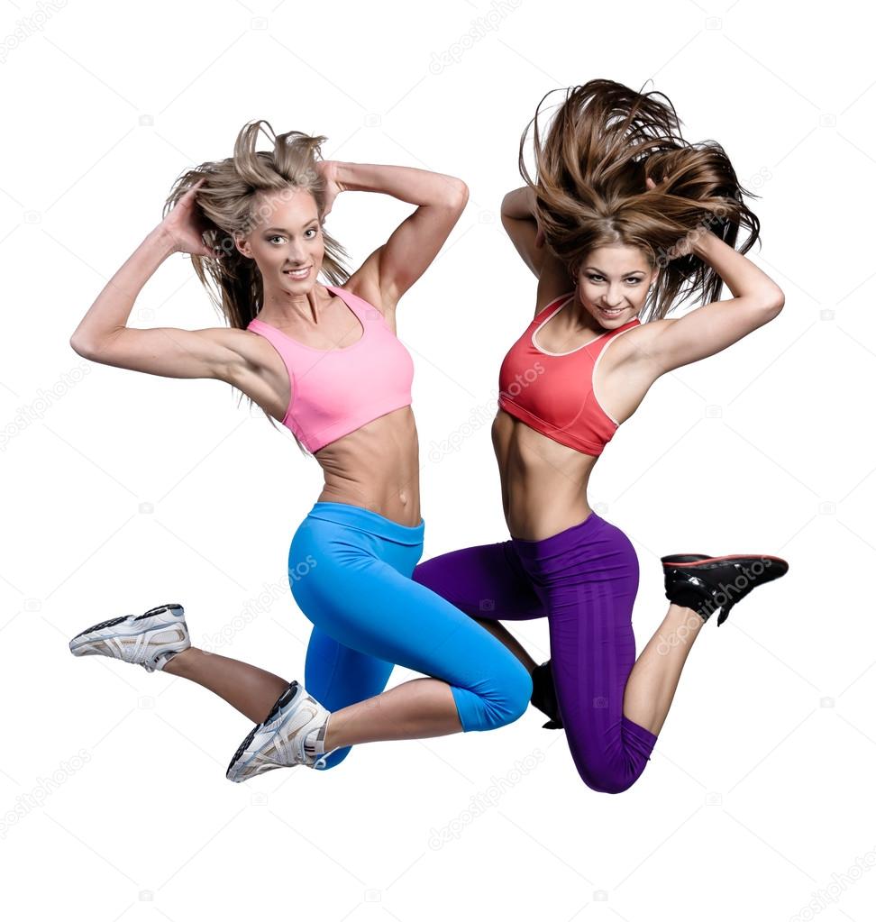Two beautiful athletic girls jumping over white background