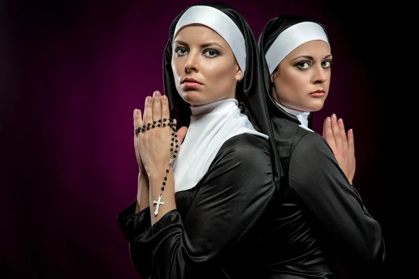 Portrét dvou atraktivních mladých jeptišek se modlí — Stock fotografie