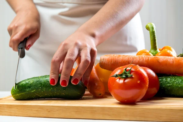Женщина режет овощи для салата — стоковое фото