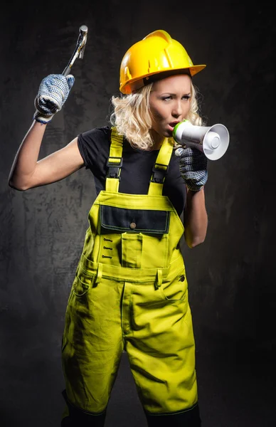 Mulher construtor atraente gritando através de megafone — Fotografia de Stock