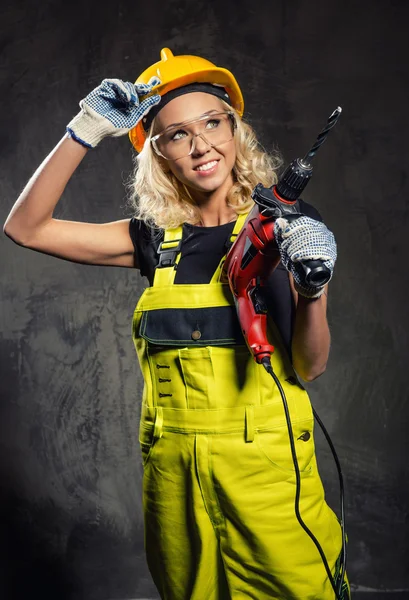 Attraktive Bauarbeiterin mit einem Bohrer in der Hand — Stockfoto